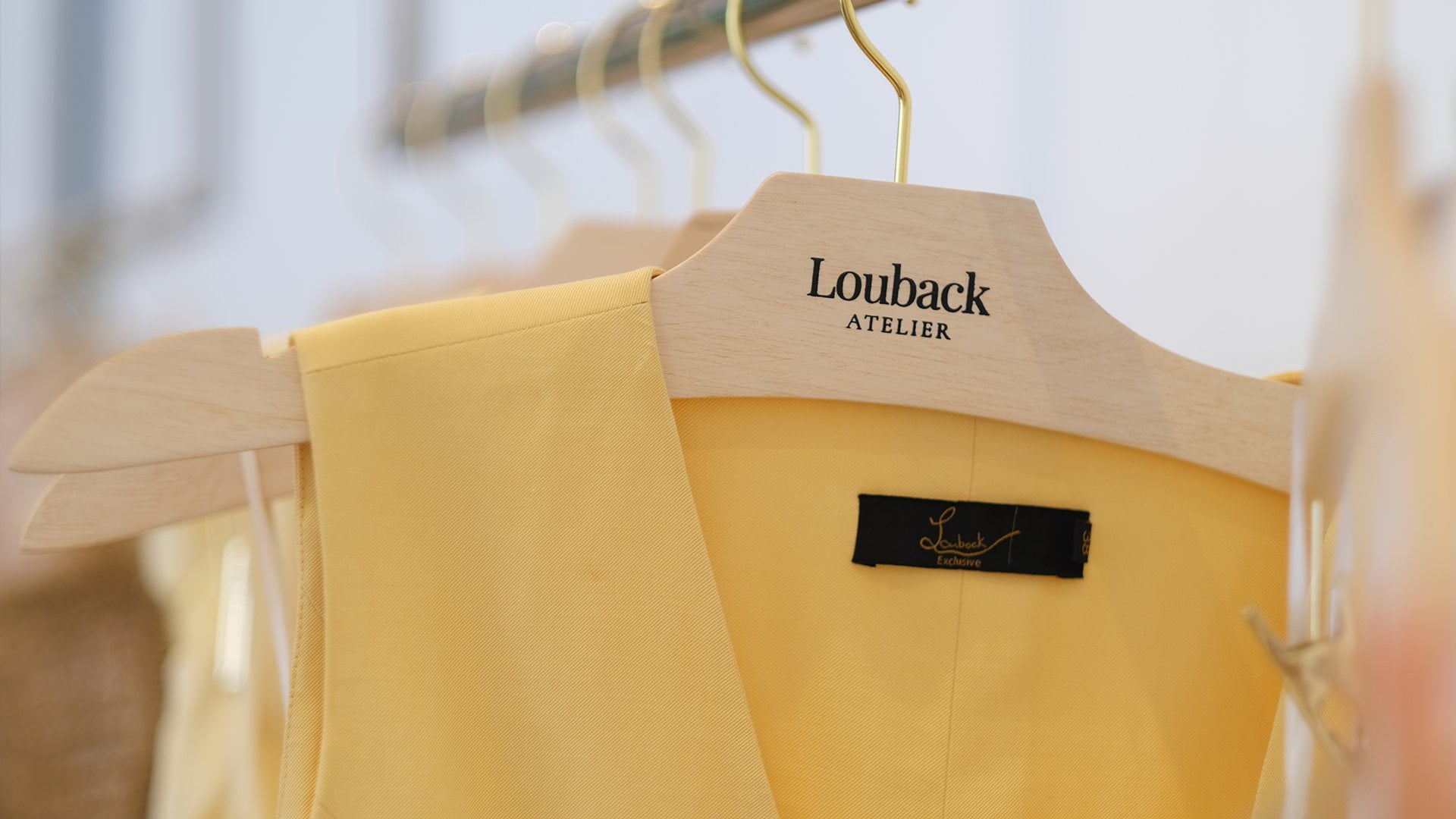 Etiqueta Louback Exclusive em colete amarelo